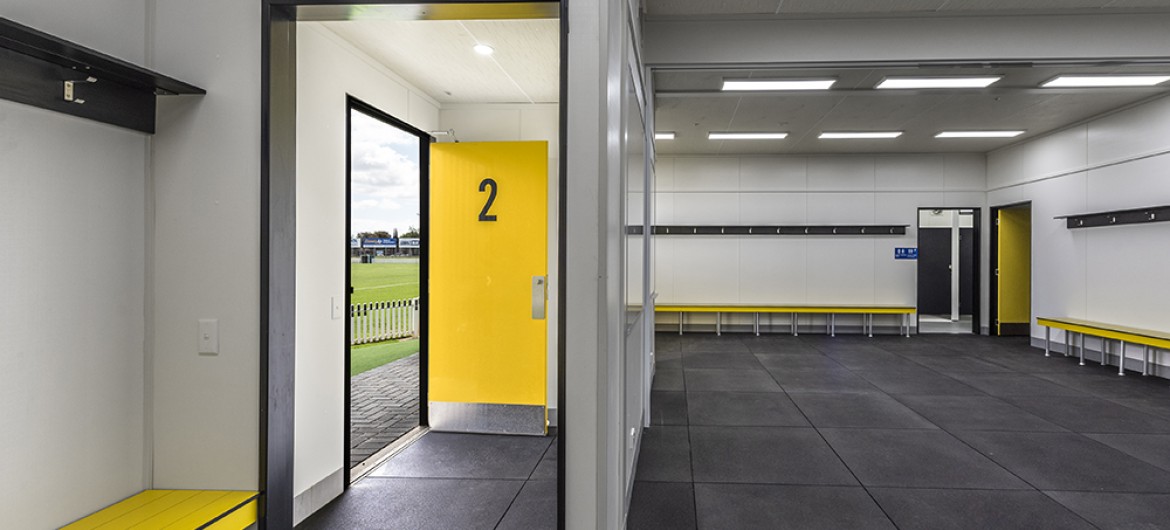 Interior Sports Change Room with White Walls, View of Entrance and Yellow Bench Seating