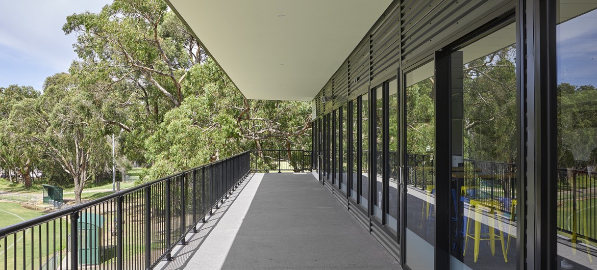 Building Exterior with Glass Doors and Balcony Facing Sports Grounds