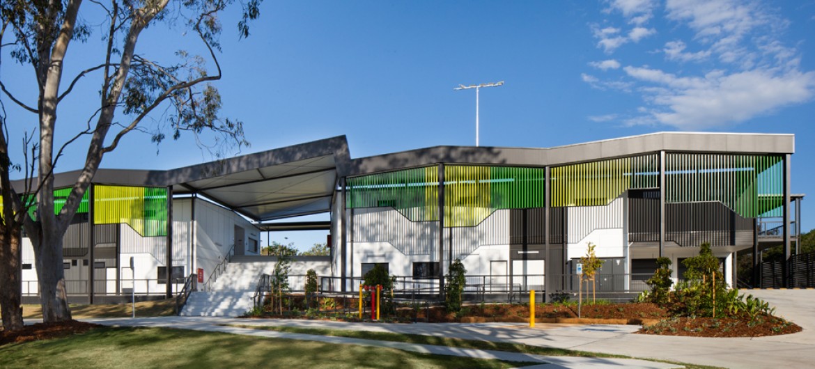 Modular Building on Lawn, with Grey Awnings and Green Facade