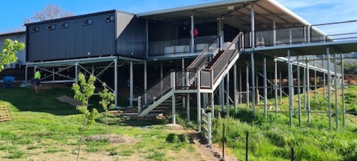 Exterior Modular Building on Grassy Field with Stairway